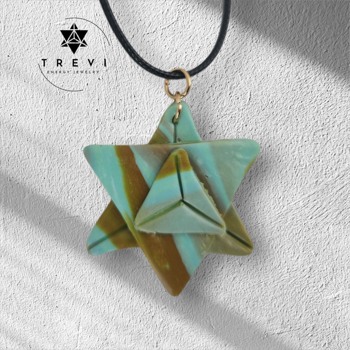 A green and brown colored merkaba-shaped pendant necklace.