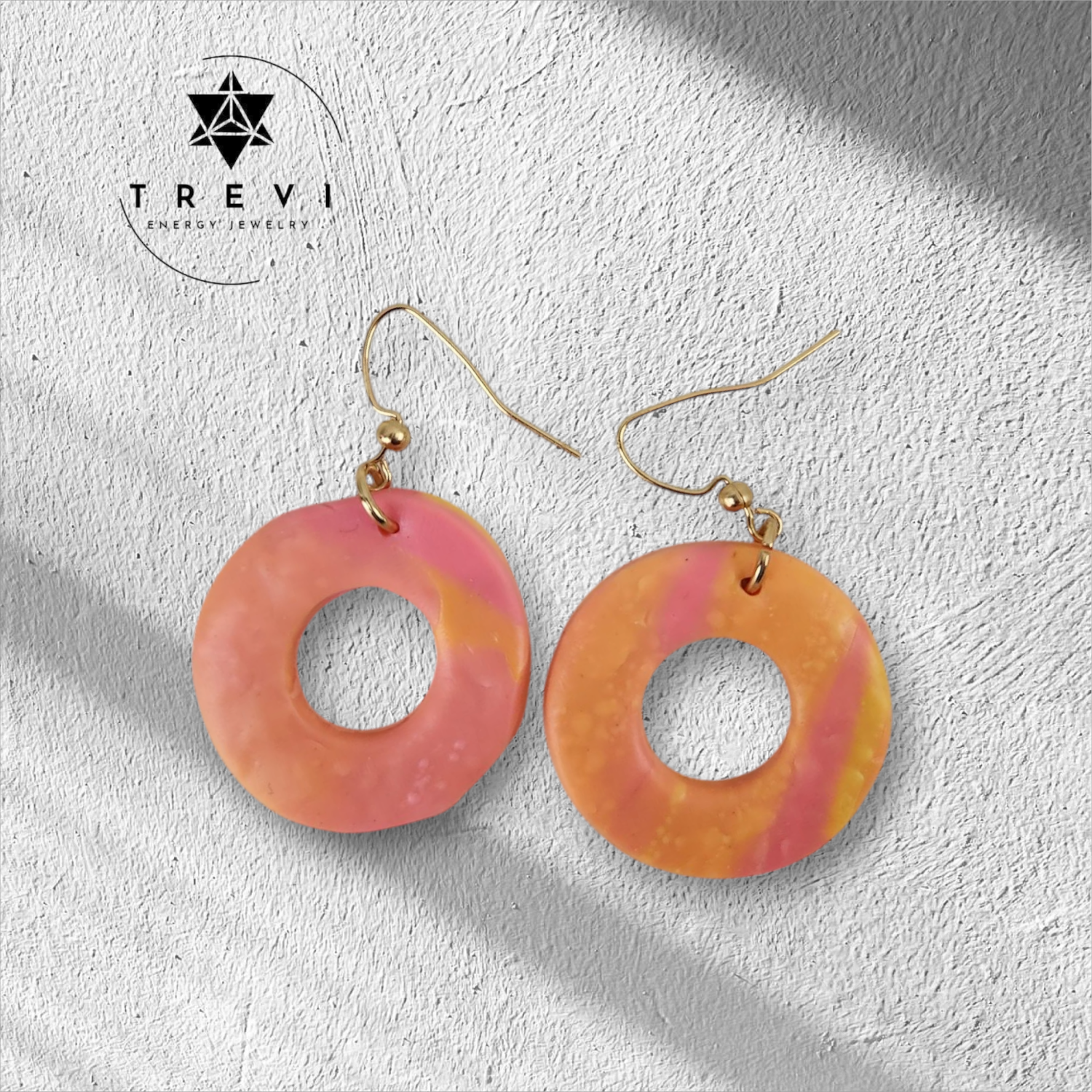A pair of hoop earrings with a pink and orange color pattern.