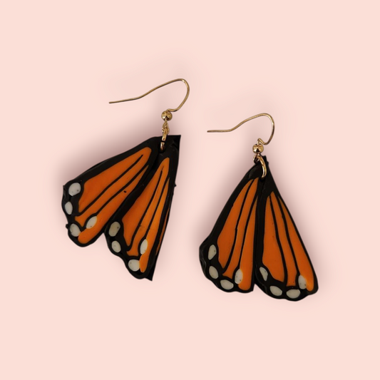 Butterfly wing earrings on a pink background